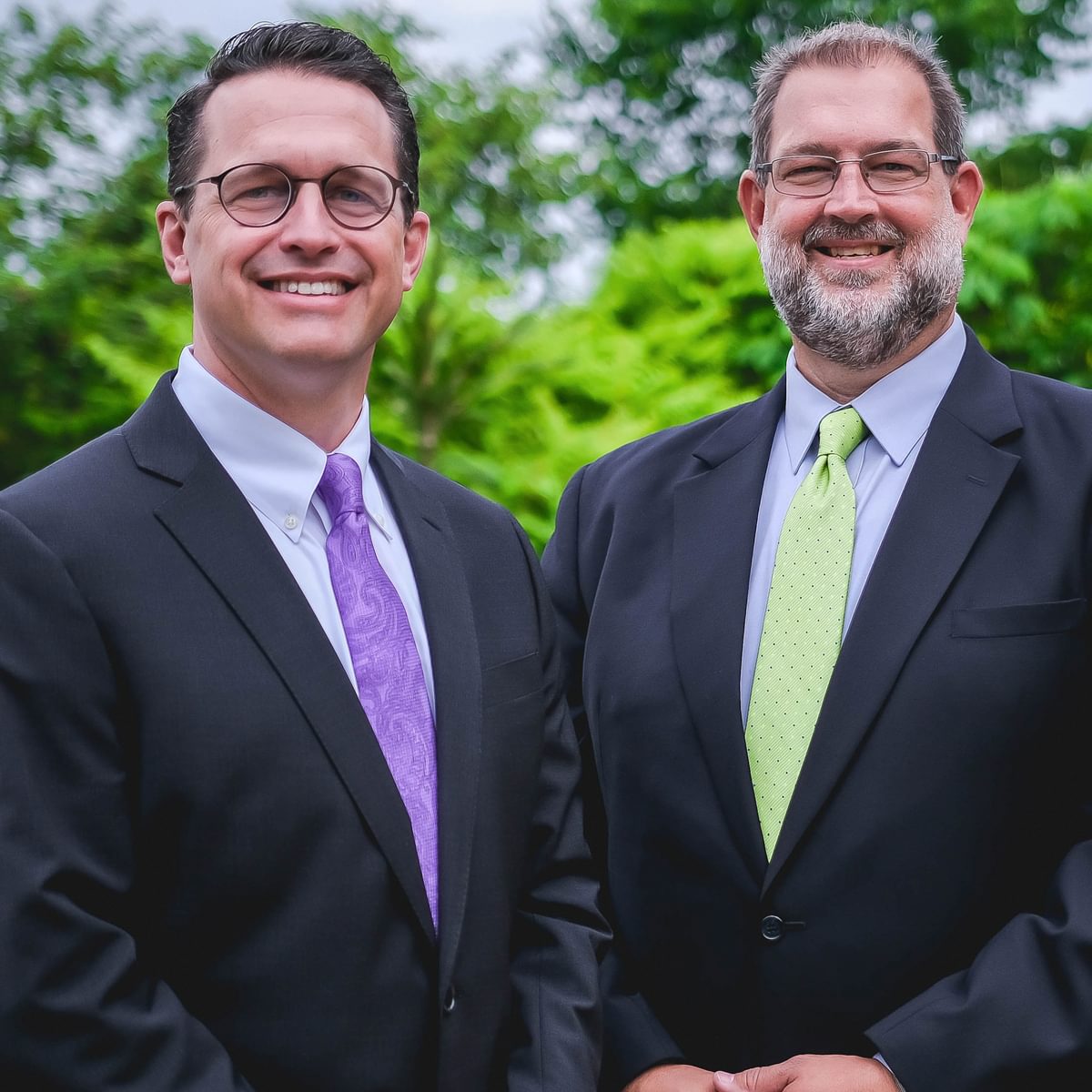 Two employees of McKinley Carter standing in front of a tree.