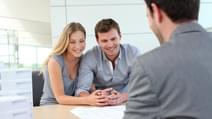 Couple in real estate agency talking to construction planner