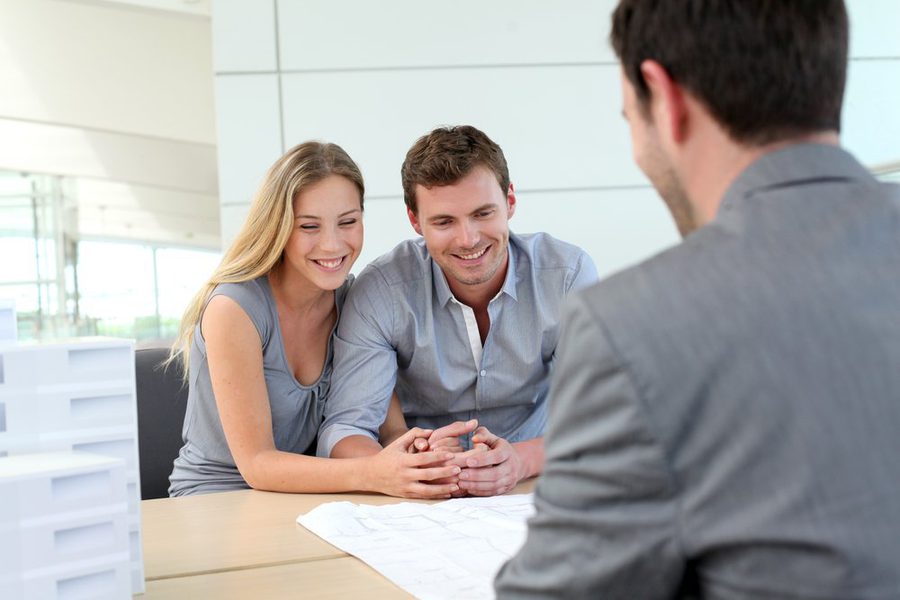 Couple in real estate agency talking to construction planner