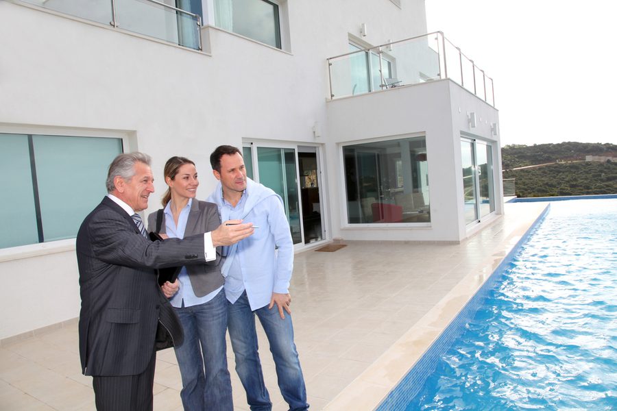 Couple visiting luxury villa with real estate agent