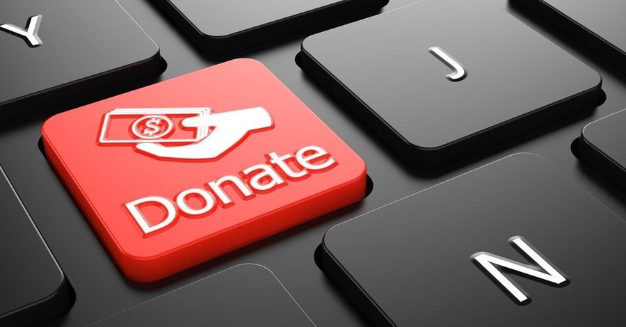 Donate with Money in the Hand Icon Red Button on Black Computer Keyboard