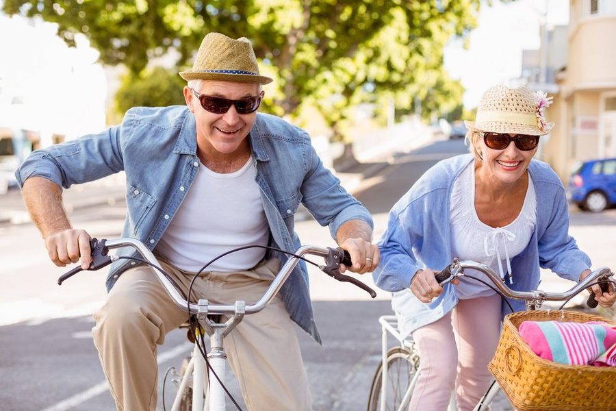 Happy mature couple going for a bike ride in the city on a sunny day 1