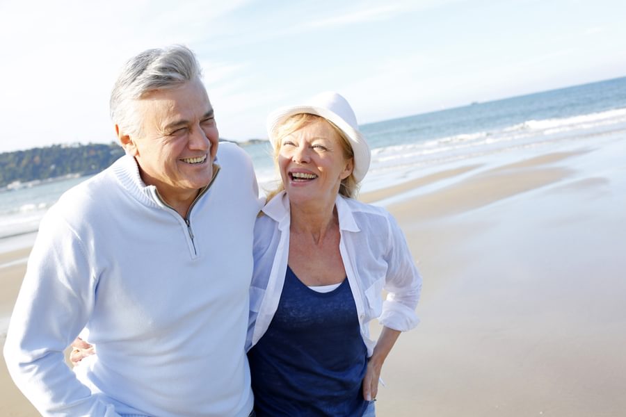 Senior couple walking on the beach in fall season 1