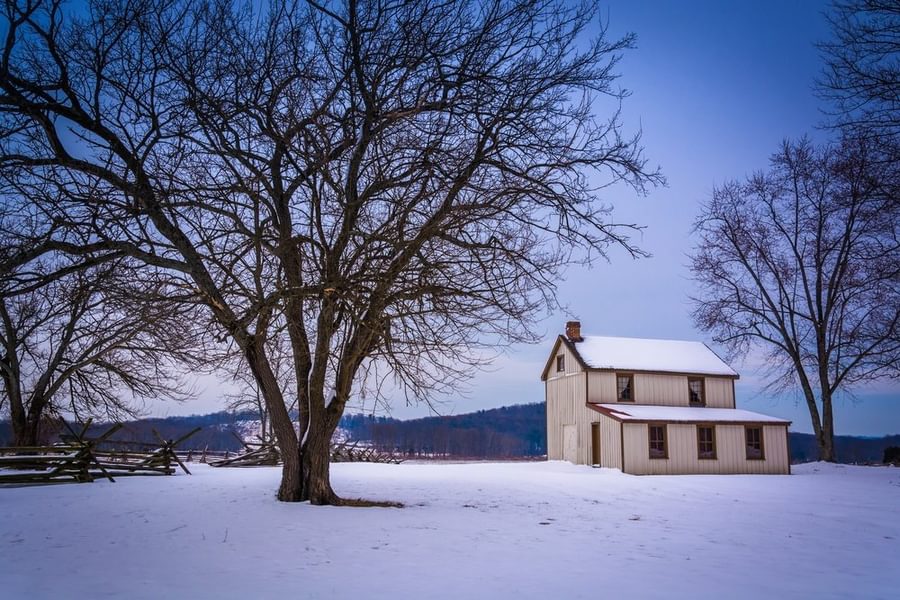 Small house and trees in a snow covered field in Gettysburg Pennsylvania
