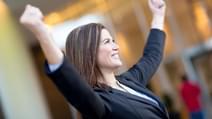 Successful business woman with arms up celebrating