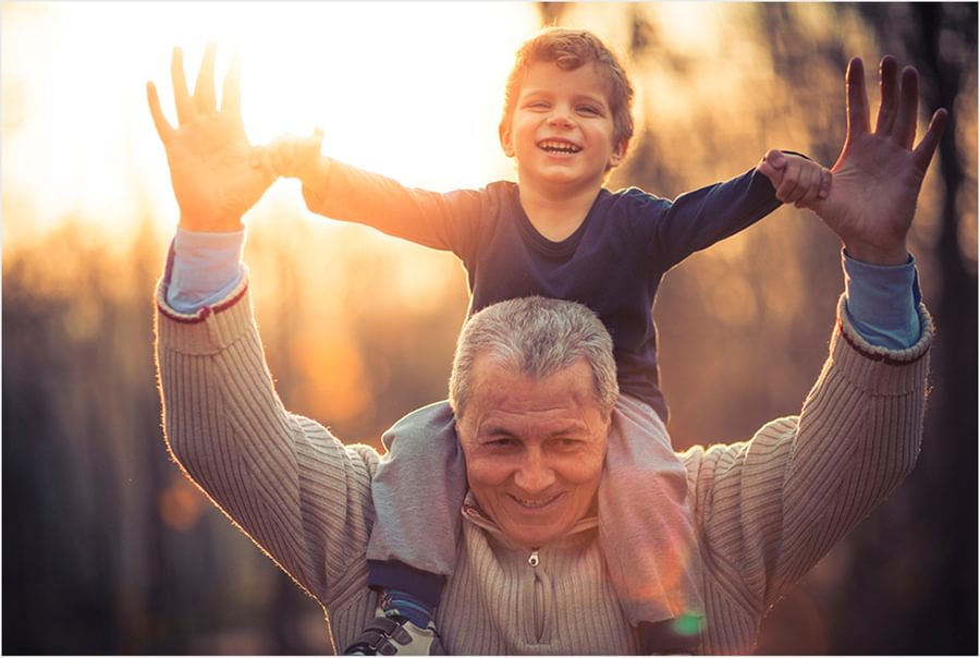 A man walking with a child on his shoulders