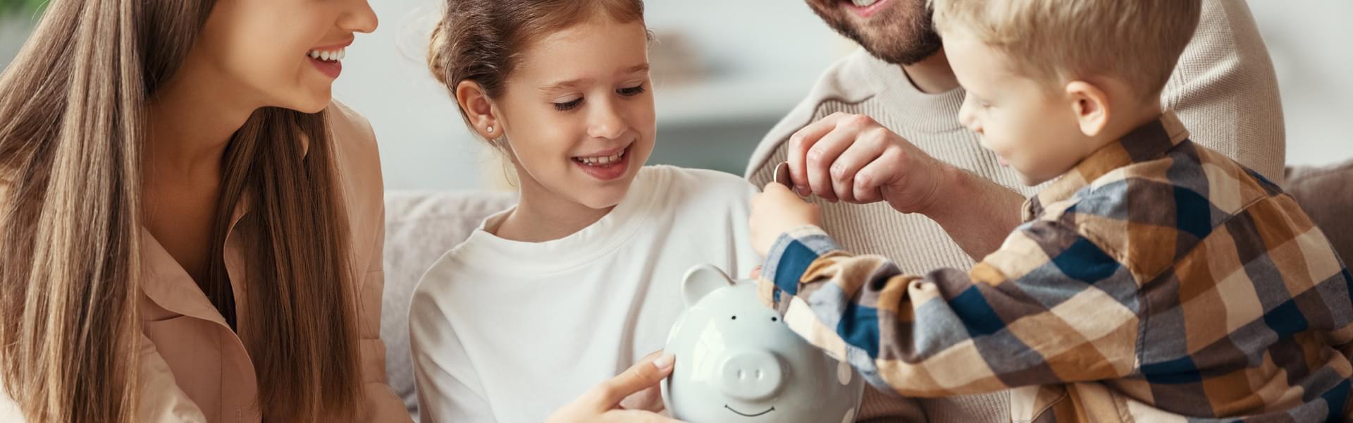 A family putting coins in a piggy bank with their children.